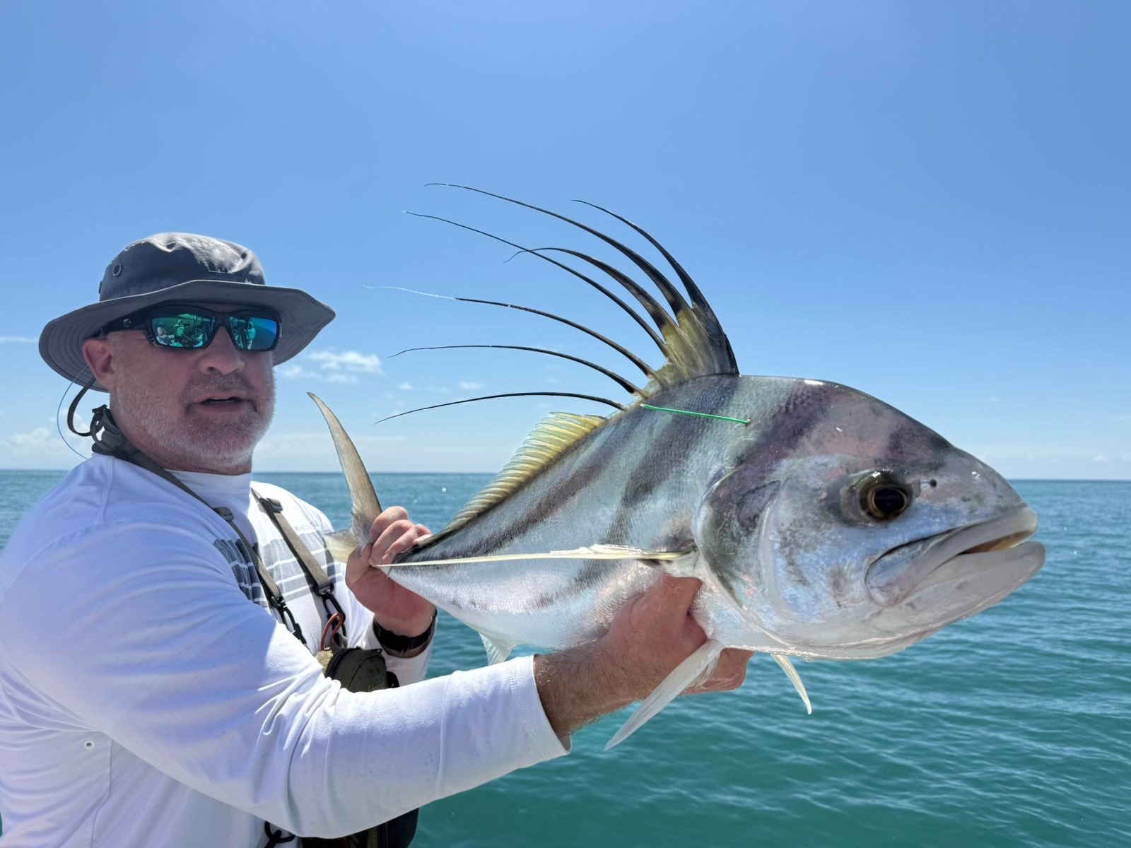 Angler presenting a roosterfish toward the camera