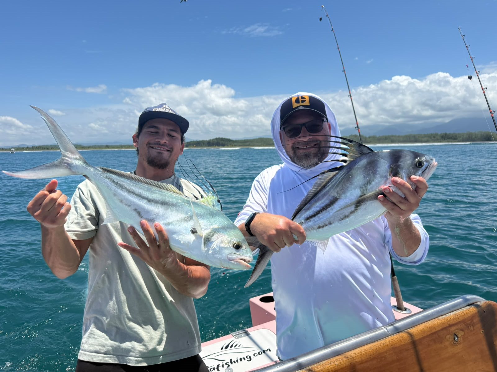 Two anglers showing several catches aboard the boat