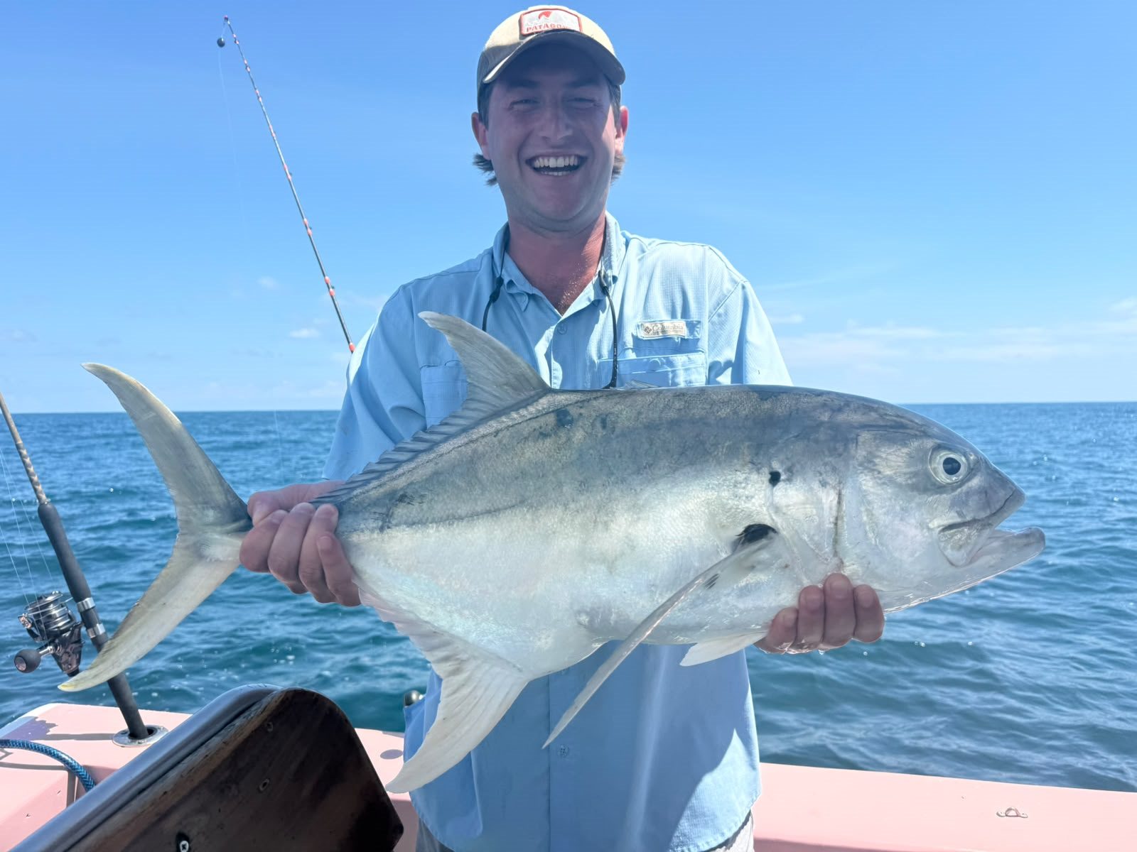 Happy angler holding a powerful silver fish