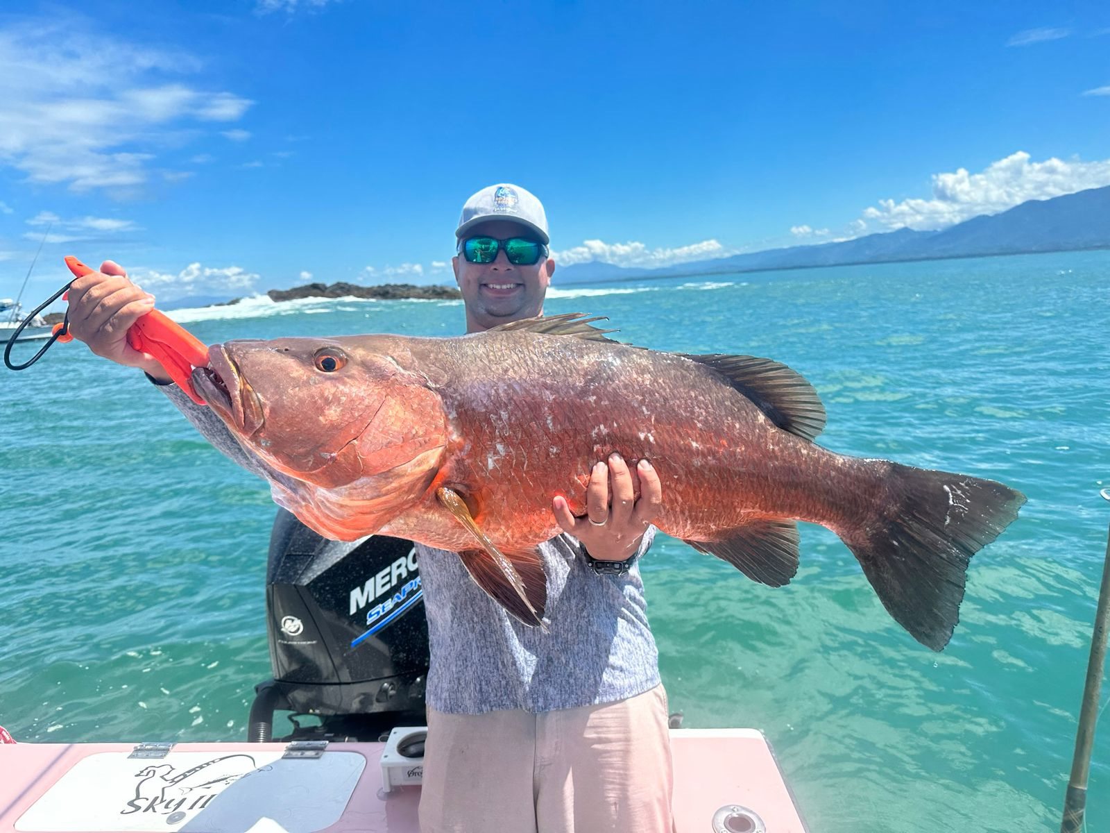 Angler holding a long red reef fish