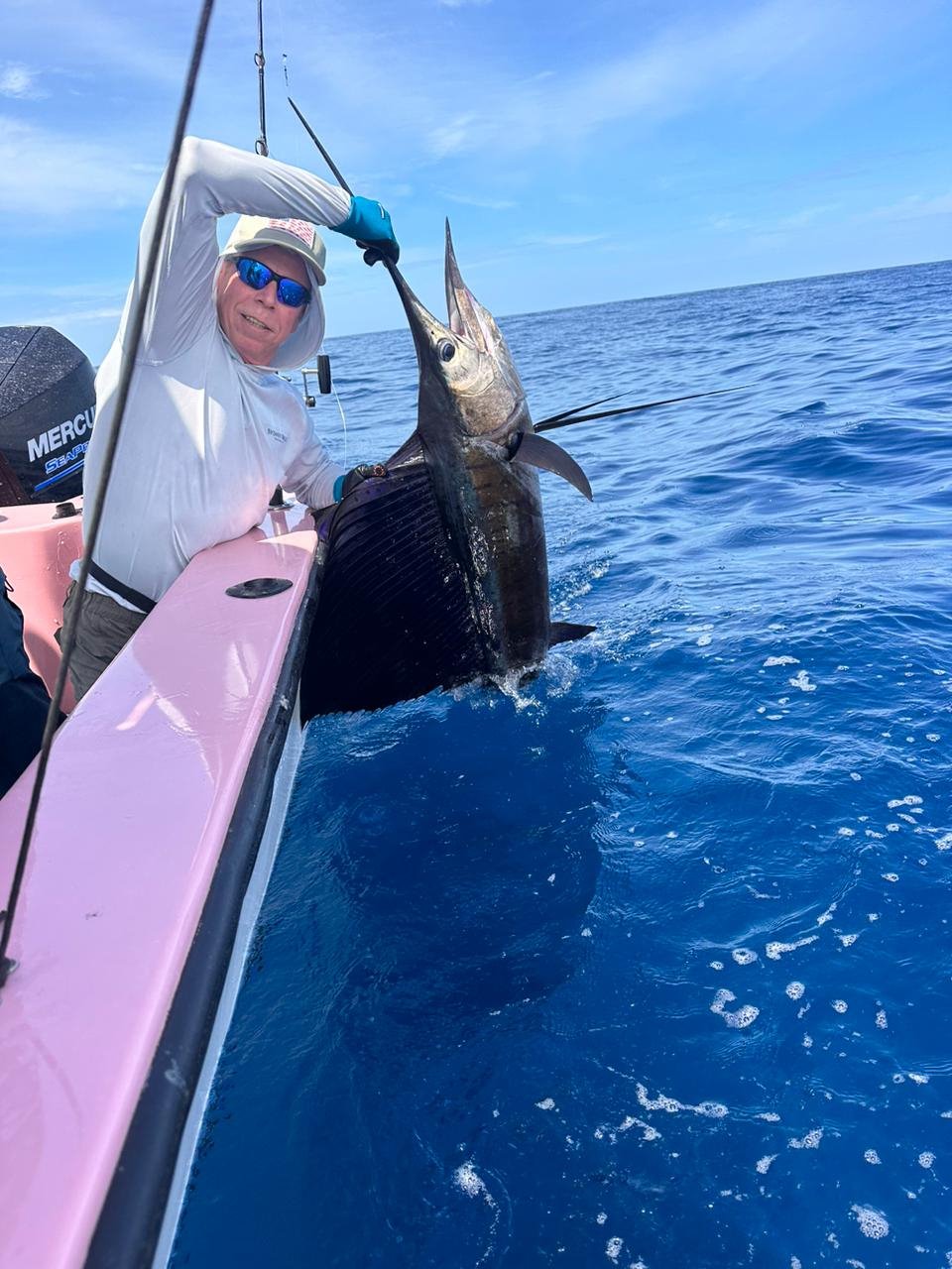 Sailfish remaining in the water beside the boat