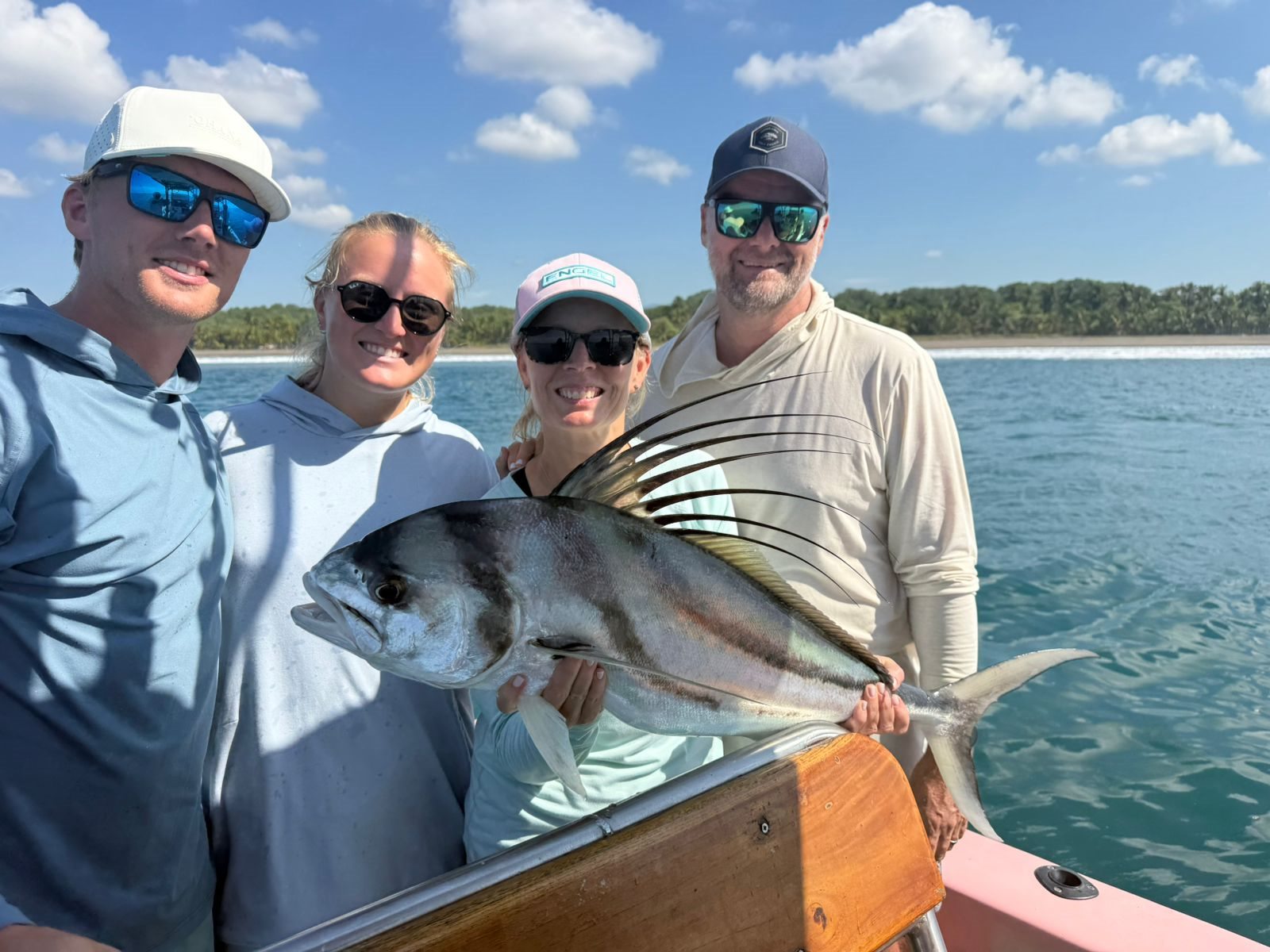 Group of anglers gathered around a large roosterfish