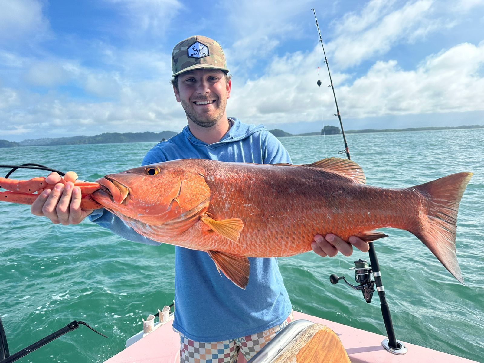 Adult angler smiling with a long red snapper